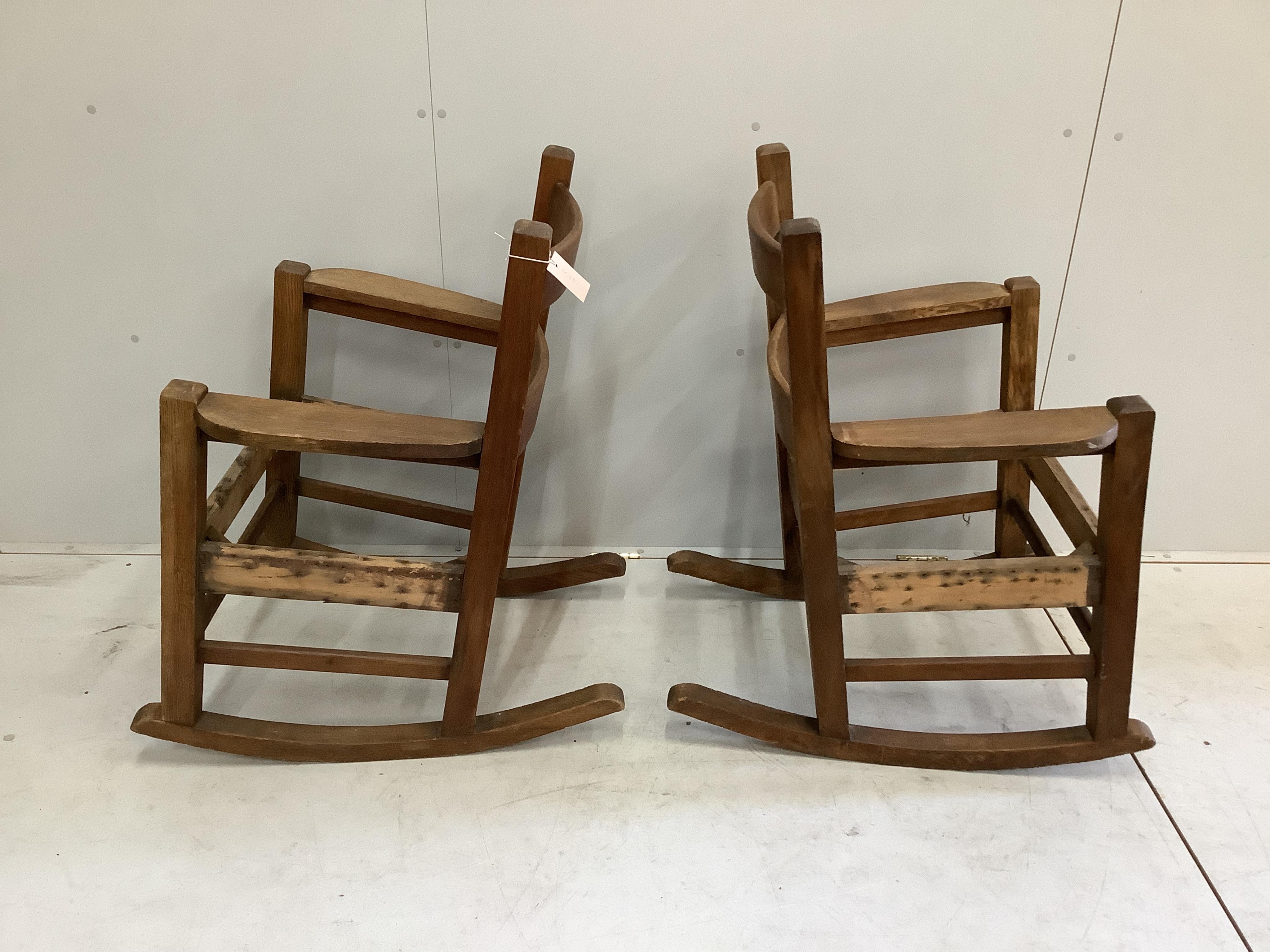 In the manner of Stickley, a pair of Arts and Crafts oak rocking chairs, width 69cm, depth 78cm, height 89cm